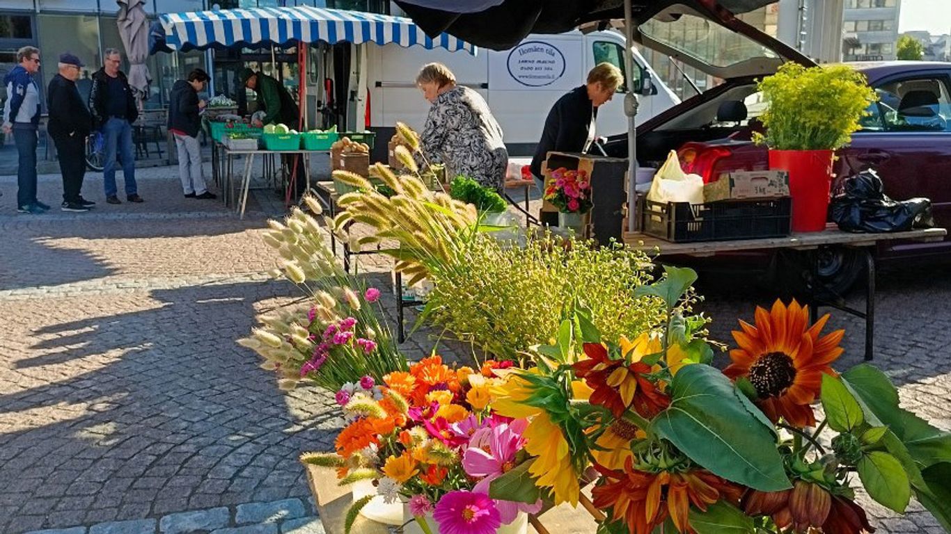Myyjiä ja asiakkaita Kouvolan kauppatorilla kesäis