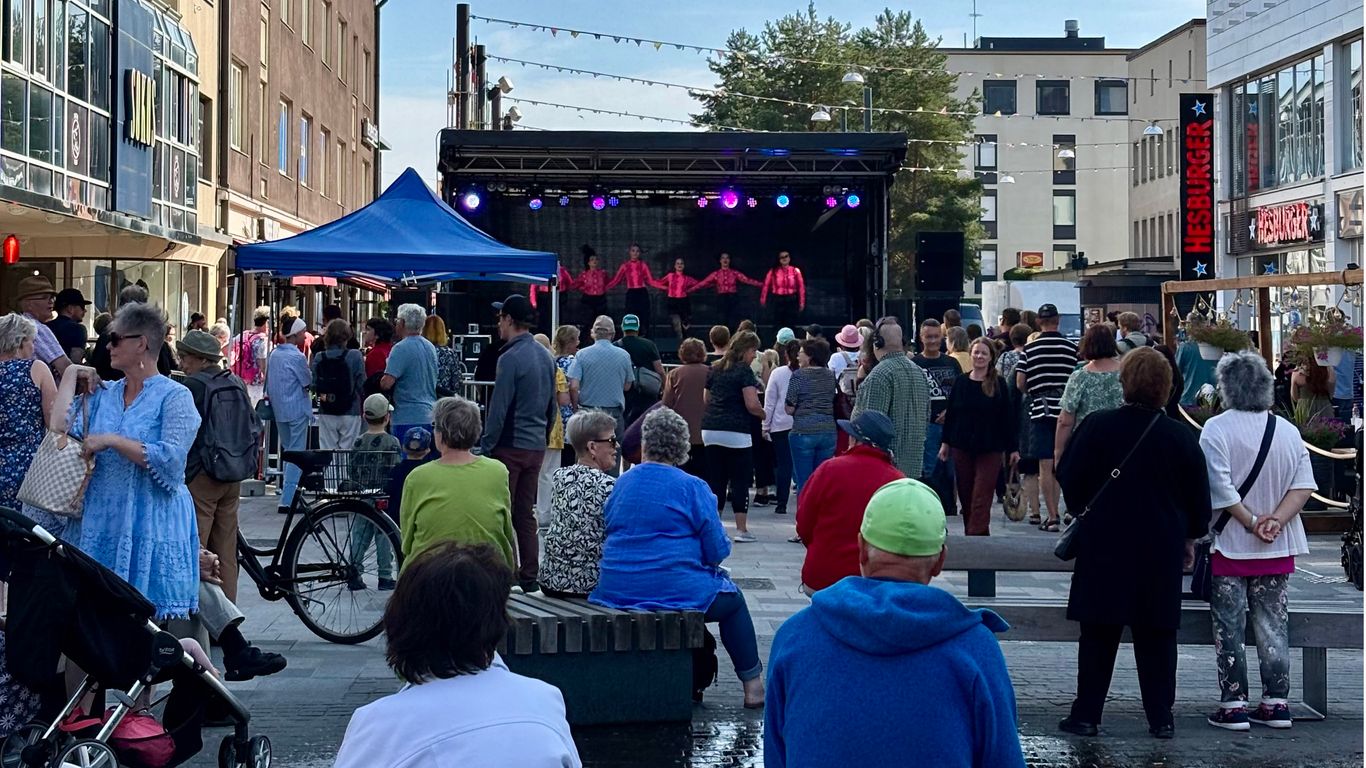 Ihmiset seuraavat tanssiryhmän esitystä kävelykatu