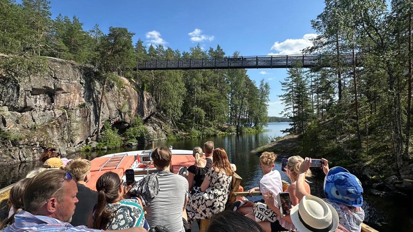Ihmiset sisävesiristeilyllä riippusillan alla