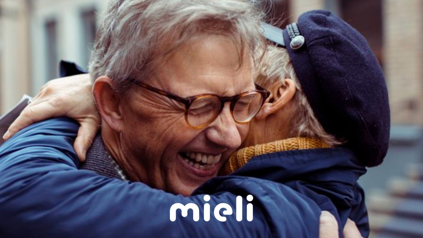 Kaksi henkilöä halaavat toisiaan iloisina